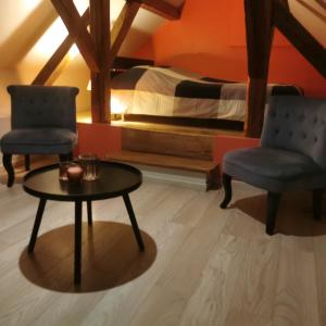 - une chambre avec deux chaises, une table et un lit dans l'établissement Gite Joël et Nathalie, à Urschenheim