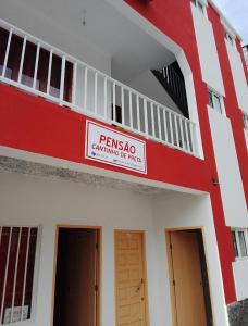 a red and white building with a sign on it at Pousada Cantinho de Preta in Seladinha