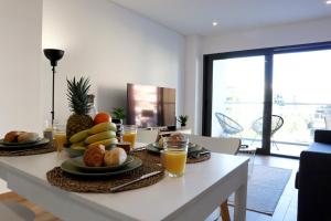 einen Tisch mit einem Obstteller und Orangensaft in der Unterkunft Monte Residence T1 in Portimão