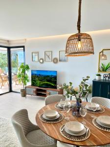 ein Esszimmer mit einem Tisch und Stühlen sowie einem TV in der Unterkunft Luxury 3 Bedroom Apartment 300m from the Beach in Fuengirola