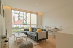 a living room with a couch and a table at Bright 1 BDR Apartment W/ Pool View by LovelyStay in Lisbon