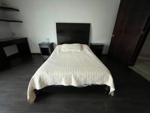 a bedroom with a bed with a white comforter at Habitación Ojo de Agua in Orizaba