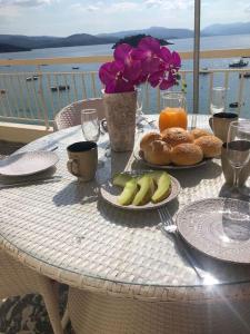 - une table avec des assiettes de pain et des fruits dans l'établissement Mama Mia apartment, Tolo beachfront, à Tolón