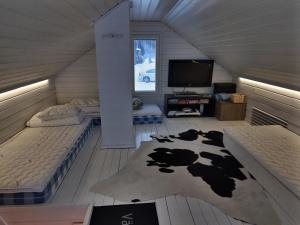een kamer met 2 bedden en een tv en een koeienkleed bij VillaNorva in Saarenkylä