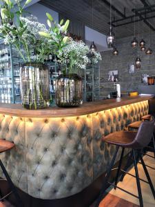 a bar with vases of flowers on top of it at Cosmopolite Hotel Nieuwpoort-Bad in Nieuwpoort