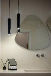 a mirror on a wall above a bathroom sink at Casa di Magi in Fira