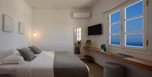 a bedroom with a large bed and a window at Casa di Magi in Fira