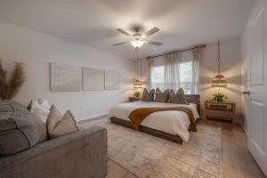 a bedroom with a bed with a ceiling fan and a couch at New Construction 1 mile from Downtown Ybor City in Tampa