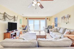 uma sala de estar com um sofá e uma televisão em Sea Breeze 608 em St. Pete Beach