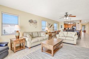 a living room with two couches and a table at Sea Breeze 608 in St. Pete Beach