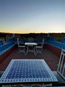 a patio with a table and chairs on a roof at Riad Dades Birds in Boumalne Dades