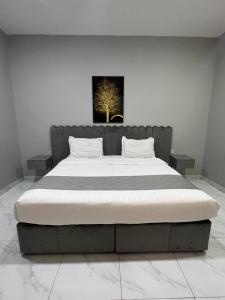 a bedroom with a large bed with a painting on the wall at Hotel Rest in Abū Qa‘ar