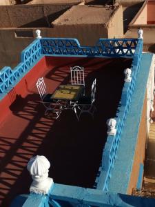 a blue bridge with a table and chairs in the water at Riad Dades Birds in Boumalne Dades