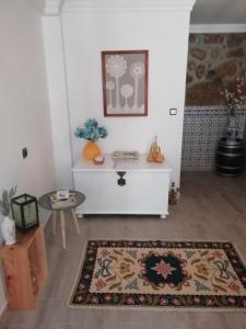 a living room with a table and a rug at Casa Aguarela, estilo familiar na Serra da Estrela in São Romão