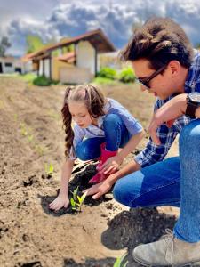 a young girl and a boy planting plants in the dirt at Hostería El Troje Experience in Riobamba