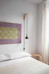 1 dormitorio con 1 cama y una pintura en la pared en Loft nel borgo, en Bracciano