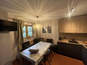eine Küche mit einem Tisch und Stühlen sowie ein Esszimmer in der Unterkunft Appartement Juri Hochkrimml in Nothdorf