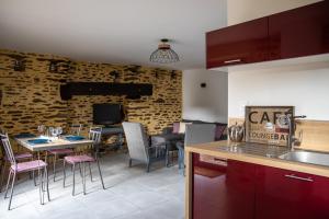 eine Küche und ein Wohnzimmer mit Tisch und Stühlen in der Unterkunft Penty - Charmante maison rénovée 50m de la mer à Banastère in Sarzeau