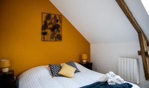 ein Schlafzimmer mit einem Bett mit gelber Wand in der Unterkunft Penty - Charmante maison rénovée 50m de la mer à Banastère in Sarzeau