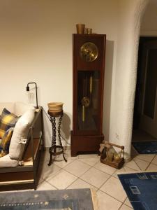 un reloj de abuelo en una habitación con sofá en Ferienwohnung Ebbe en Attendorn