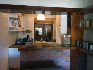 eine Küche mit einer Theke und einer Ziegelwand in der Unterkunft A Casa de São Pedro de Moel in São Pedro de Muel