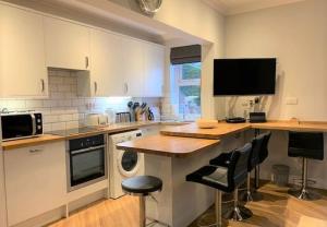 Una cocina con un mostrador con sillas y una encimera. en Beach Apartment - Seafront Apartment, en Filey