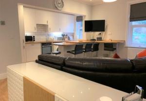 Una sala de estar con un sofá de cuero y una cocina. en Beach Apartment - Seafront Apartment, en Filey 12 fotos más