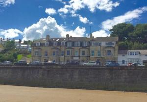 un gran edificio de ladrillo con coches estacionados frente a él en Beach Apartment - Seafront Apartment, en Filey