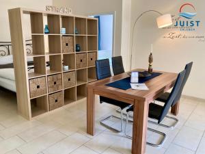 una oficina con mesa de madera y sillas en Landhaus Gertrude 106 - Wohnung Ida, en Juist