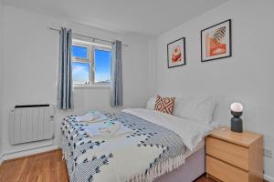 ein weißes Schlafzimmer mit einem Bett und einem Fenster in der Unterkunft Finest Retreats - White House Gardens in Southampton
