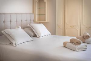 Una cama blanca con toallas y almohadas. en Neptune Suite-Hosted by Sweetstay, en Gibraltar