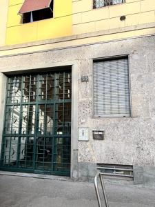 a building with green doors and a window at Kibilù - Via Taormina - Ospedale Niguarda - Isola in Milan