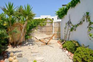 a garden with a hammock and a fence at L'olivier Milos in Plaka Milou