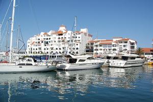un groupe de bateaux amarrés dans un port de plaisance avec un grand bâtiment dans l'établissement Neptune Suite-Hosted by Sweetstay, à Gibraltar