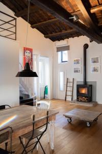 sala de estar con mesa de madera y chimenea en Loft nel borgo, en Bracciano