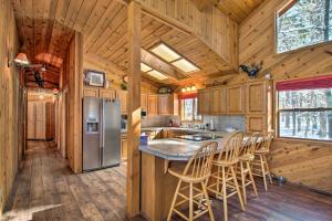 eine Küche mit einem Kühlschrank und Stühlen in einer Hütte in der Unterkunft Pinetop Cabin with Private Patio on Eighth Green! in Indian Pine