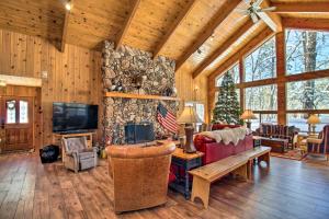 ein Wohnzimmer mit einem großen Steinkamin in einer Hütte in der Unterkunft Pinetop Cabin with Private Patio on Eighth Green! in Indian Pine