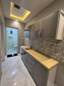 una cocina con armarios de acero inoxidable y fregadero en Hotel Rest en Abū Qa‘ar