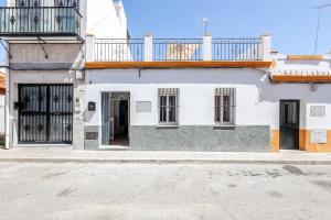 uma casa branca e cinzenta com uma varanda em Camas casa a 5 min de Sevilla con piscina em Camas