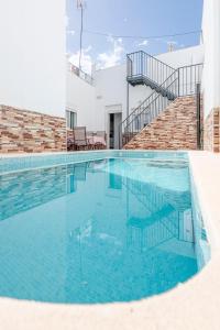 uma piscina com água azul num edifício em Camas casa a 5 min de Sevilla con piscina em Camas