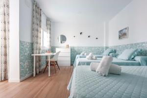 um quarto com 2 camas e uma mesa em Camas casa a 5 min de Sevilla con piscina em Camas
