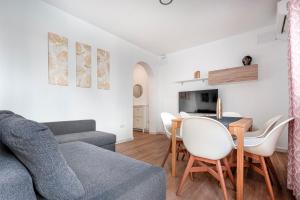 uma sala de estar com um sofá e uma mesa em Camas casa a 5 min de Sevilla con piscina em Camas
