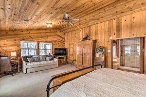 Schlafzimmer mit einem Bett und einem Deckenventilator in der Unterkunft Pinetop Cabin with Private Patio on Eighth Green! in Indian Pine