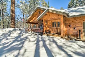 eine Hütte im Wald im Schnee in der Unterkunft Pinetop Cabin with Private Patio on Eighth Green! in Indian Pine