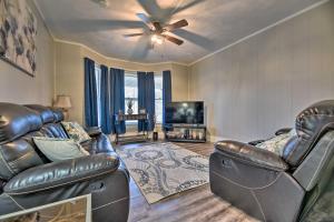 a living room with leather furniture and a flat screen tv at Niagara Falls Townhome Near Wineries! in Niagara Falls