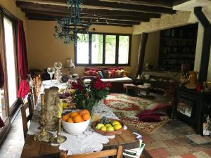 - un salon avec une table et des fruits dans l'établissement Au Pain des Anges, à Saint-Gervais en-Belin