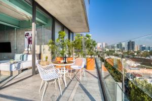 a balcony with a table and chairs and a bed at Collections by ULIV Polanco in Mexico City