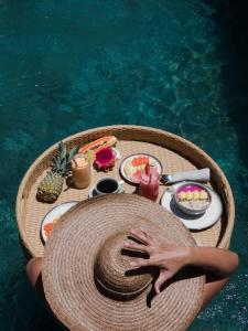 a person laying on a table with food in the water at La Siesta bungalows & Cuisine in Gili Islands