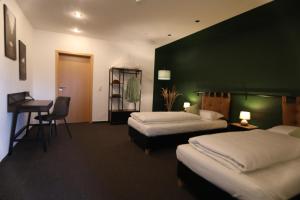 Habitación de hotel con 2 camas y escritorio en Haoma Lodge Oase I Superzentral I Free Parking I WLAN I Netflix, en Erlangen