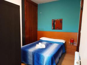niebieska sypialnia z łóżkiem z ręcznikiem w obiekcie Alcazaba w Grenadzie